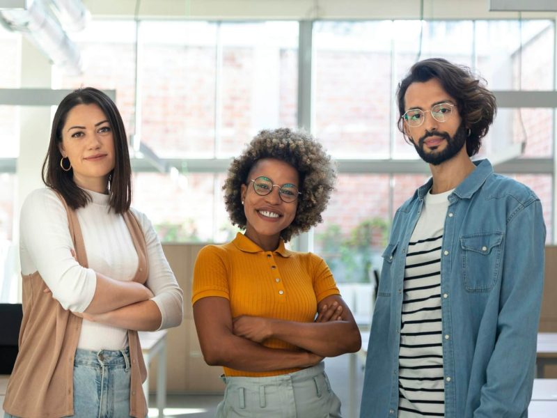 multiracial-coworkers-looking-at-camera-standing-in-bright-spacious-co-working-office-space-.jpg