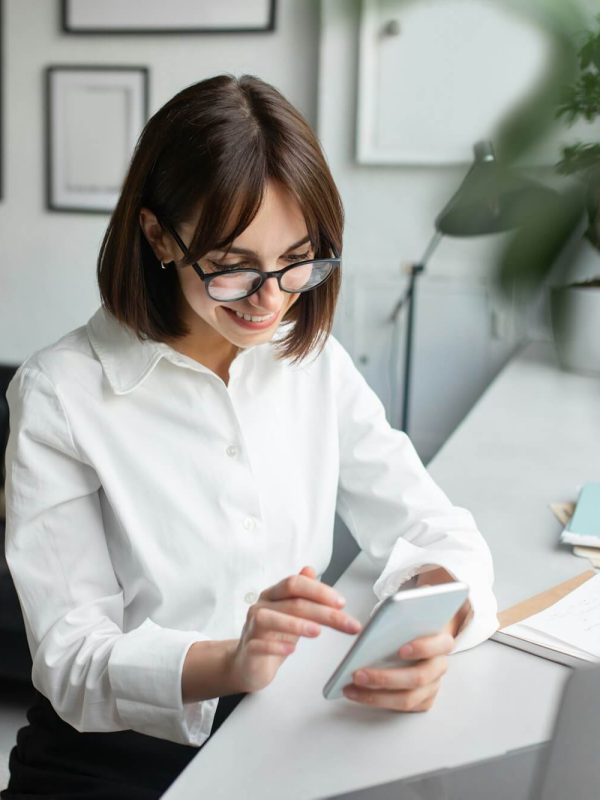 young-female-employee-using-cellphone-at-workplace-in-office-or-coworking-space-enjoying-break-at.jpg
